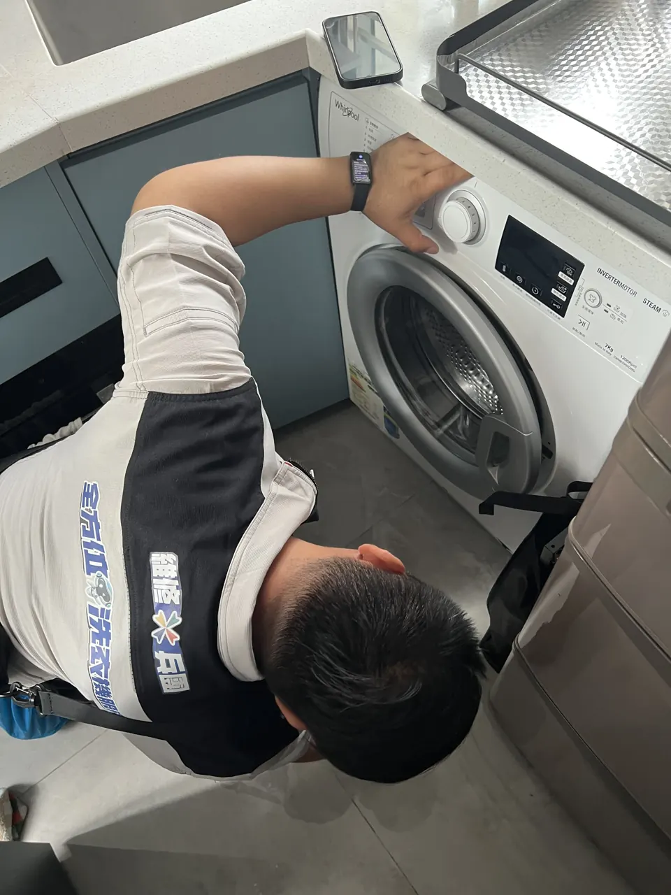 師傅一手扶住洗衣機檢查