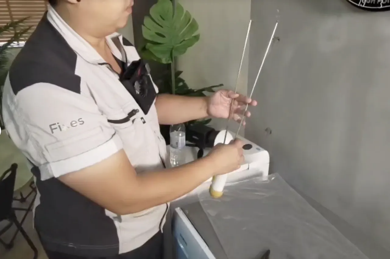 師傅喺工場拎住零件示範